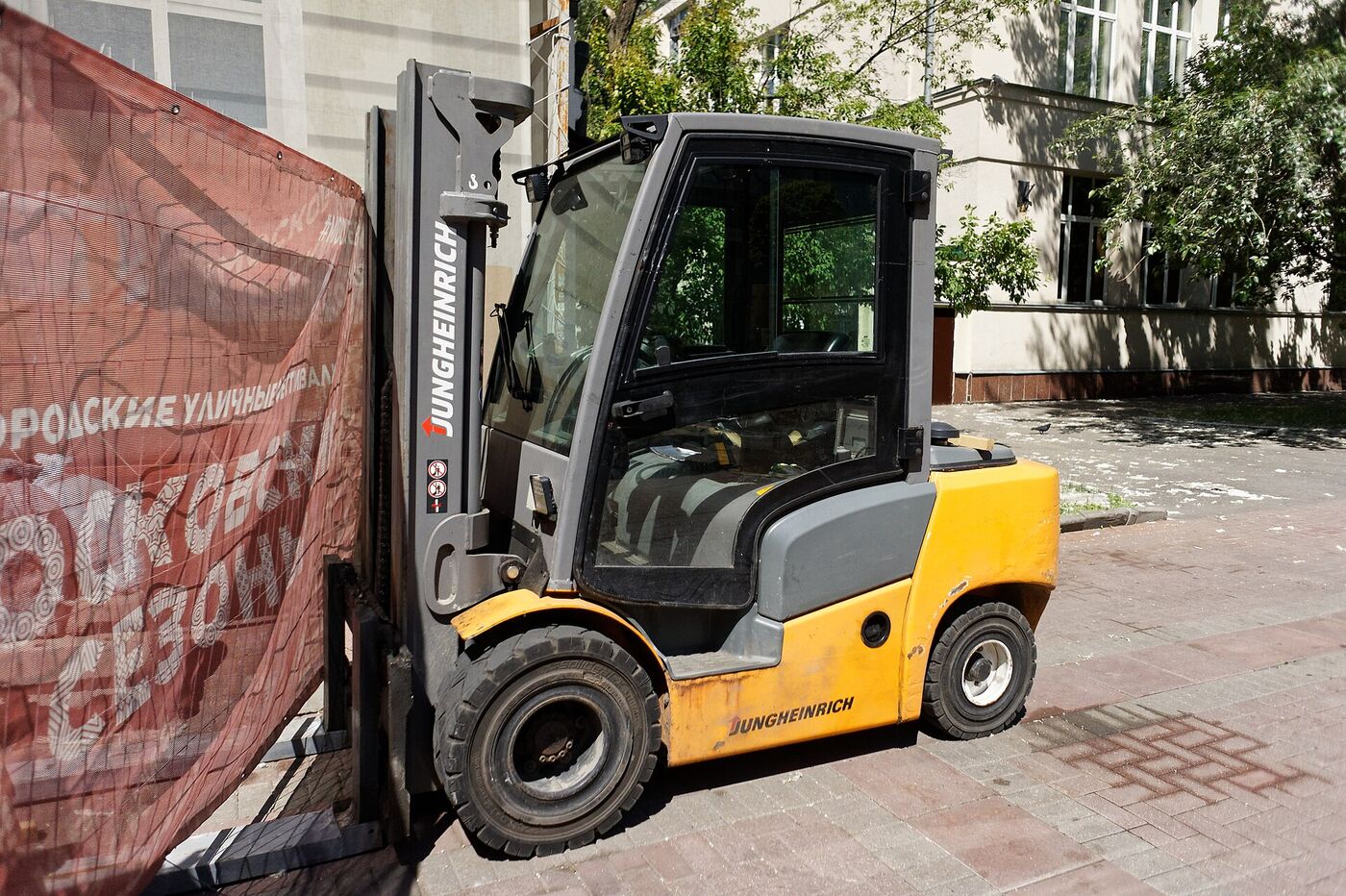 An electric counterbalance forklift working outside a building